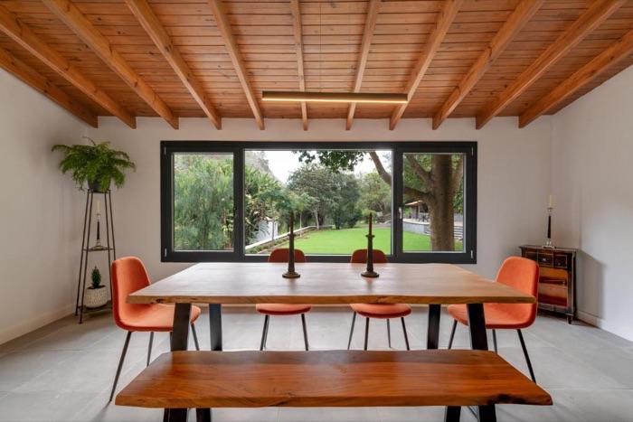Comedor con una mesa larga de madera frente a un gran ventanal