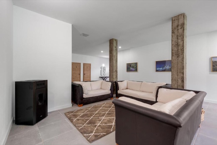 Sala de estar con sofás y columna de madera
